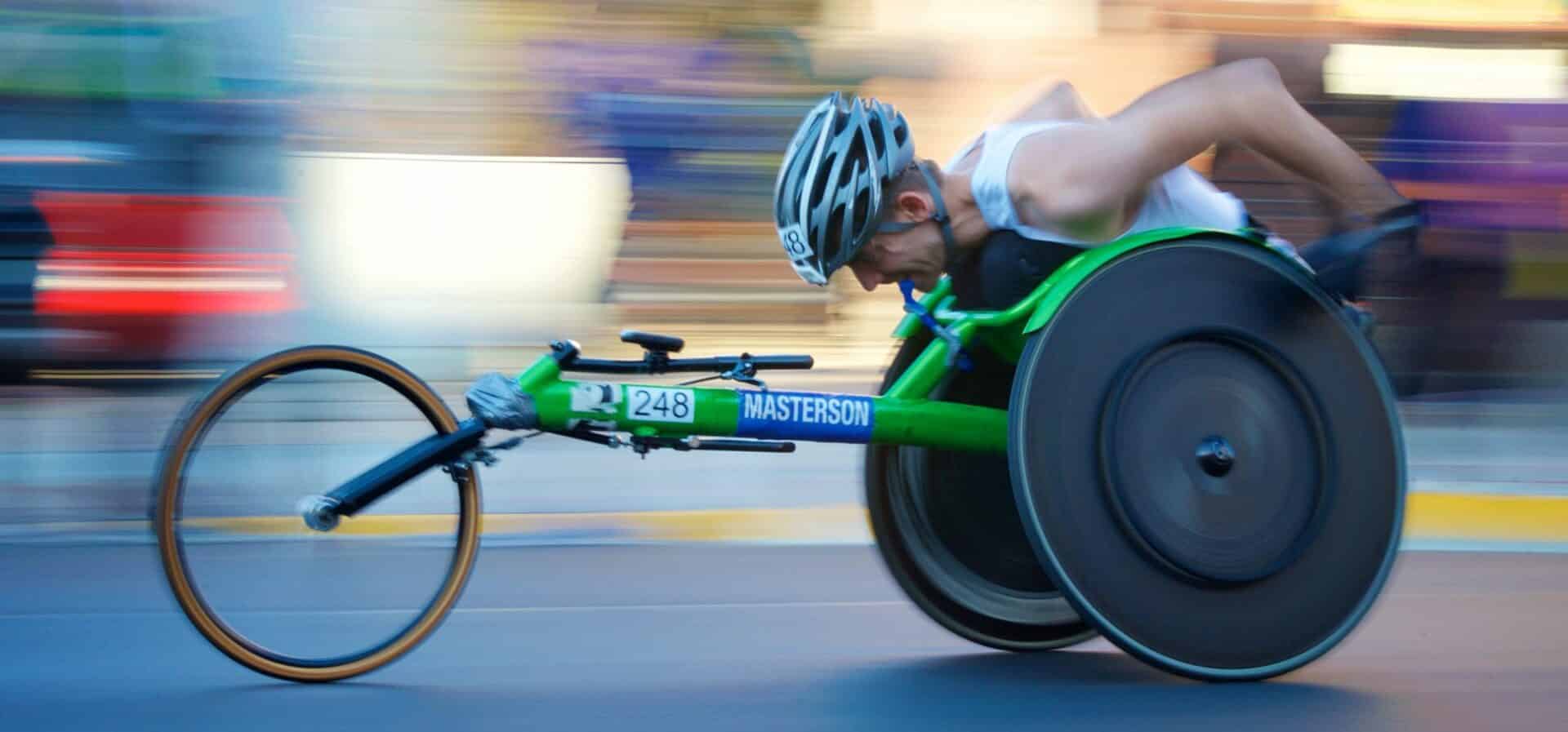 man riding green racing wheelchair